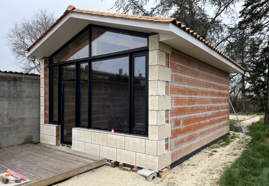 Fenêtre en aluminium anthracite posée sur une maison neuve en briques.